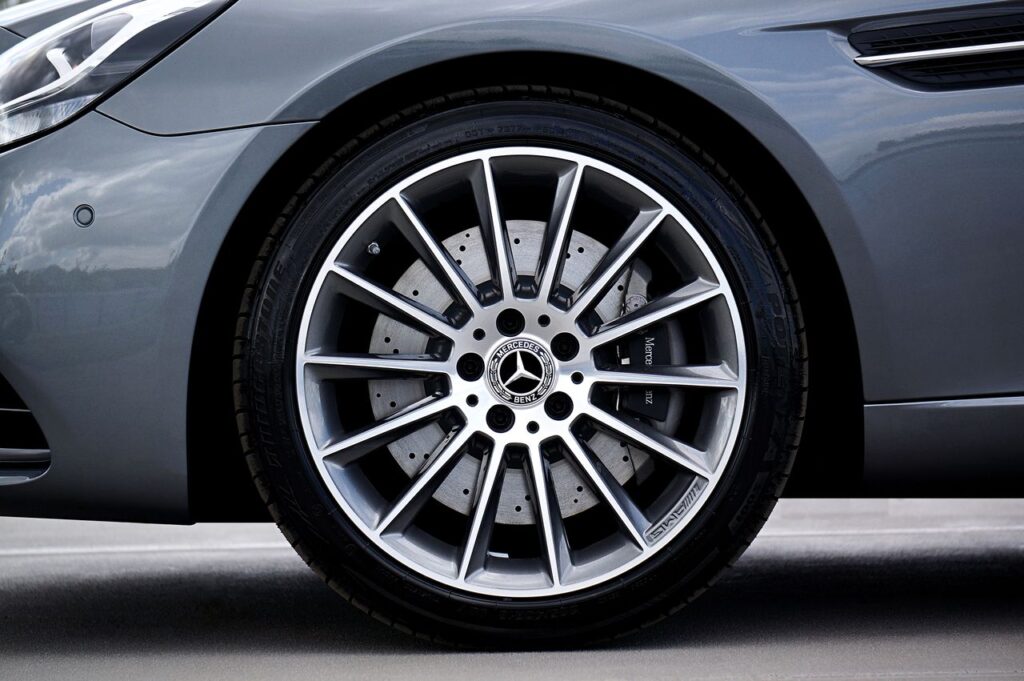 Close-up of a silver and black multi-spoke Mercedes-Benz AMG alloy wheel showing a drilled brake rotor.