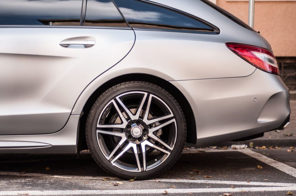 Side view of a matte silver Mercedes-Benz AMG station wagon featuring two-tone split-spoke alloy wheels.