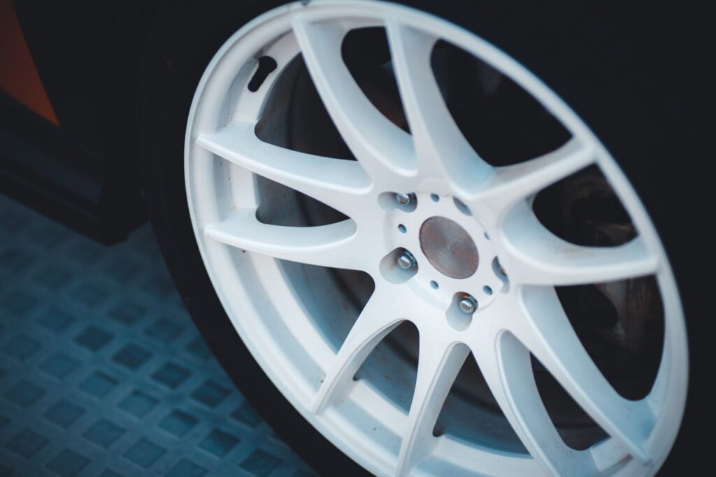Close-up of a white multi-spoke sport alloy wheel mounted on a car tire.